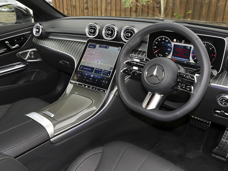 Mercedes-Benz CLE cockpit from the driver's side showing the steering wheel, dashboard, centre console, infotainment screen and some of the front seats