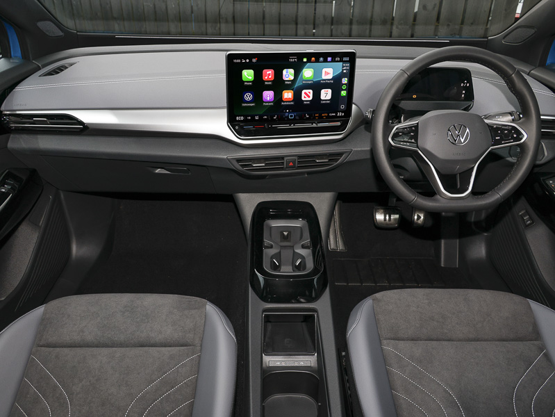 The VW ID.4's cockpit from above, showing the bottom of the driver and passenger seats, the whole dashboard, centre console and controls, infotainment screen and the bottom of the windscreen