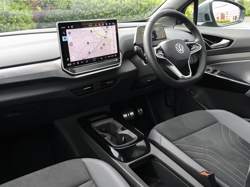 The VW ID.5's cockpit, showing the bottom of the driver and passenger seats, the dashboard, centre console and controls, infotainment screen, steering wheel and the bottom of the windscreen